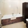 Rénovation salle de bains aspect matière, baignoire et douche sans joint, crédence aluminium composite briques rouges